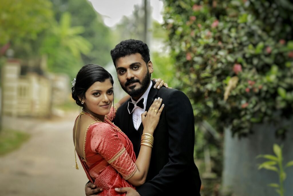 A beautiful South Asian couple poses elegantly in traditional attire outdoors, capturing a romantic wedding moment.